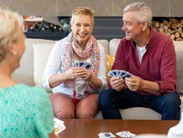 Retired couple enjoying a friendly game of cards with their neighbours in an Melbourne retirement village.